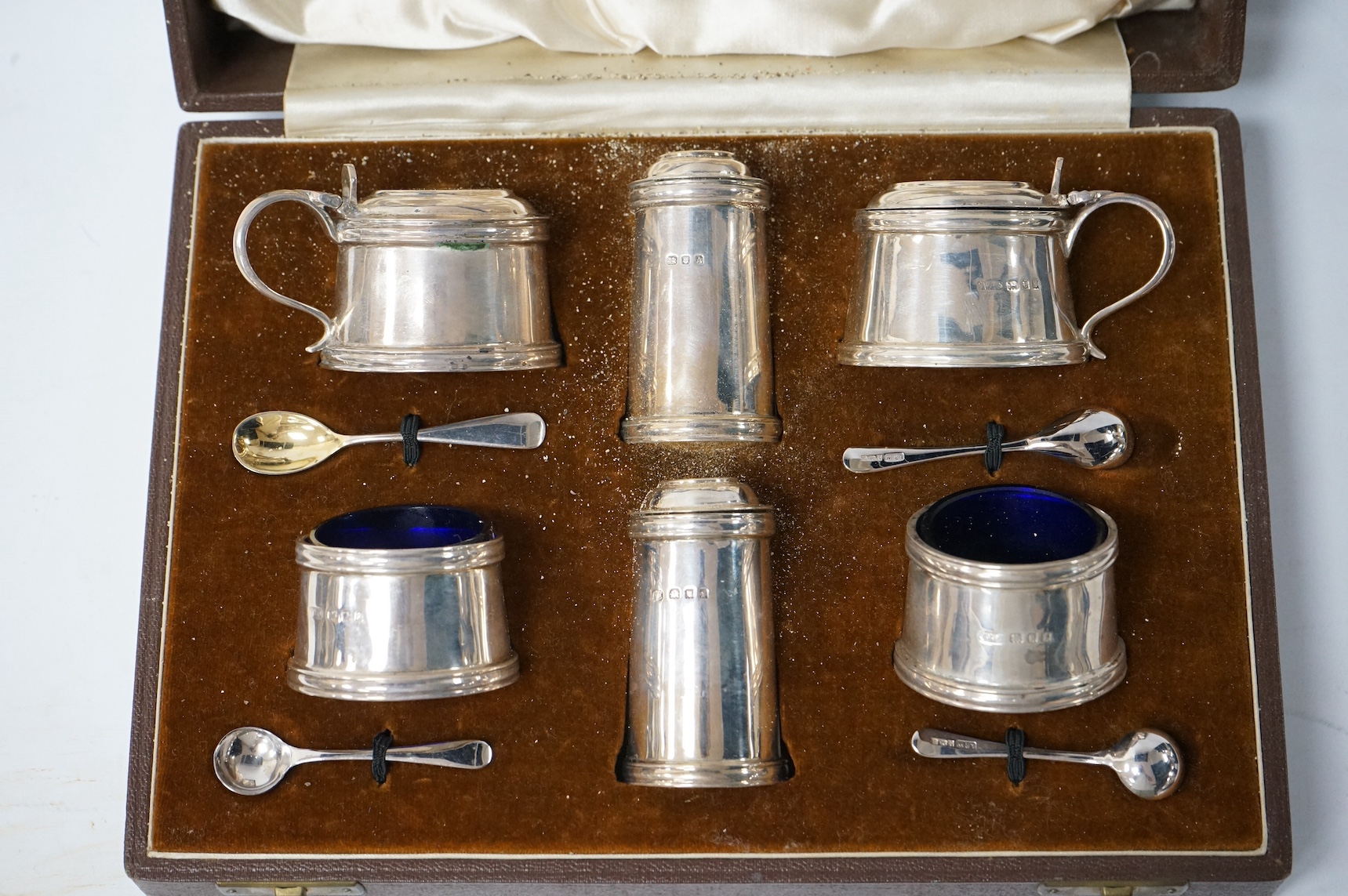 A cased George V silver six piece condiment set, by Josiah Williams & Co, with four later associated silver condiment spoons. Condition - fair